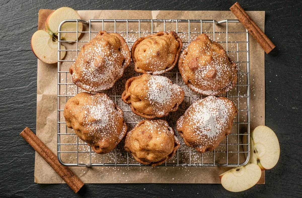 Beignets aux pommes dorés et croustillants saupoudrés de sucre glace sur une grille de refroidissement